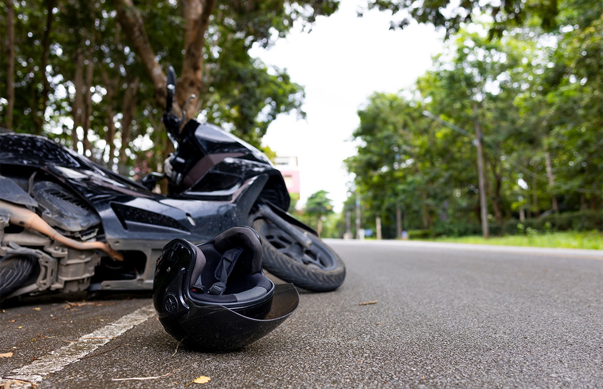 Scooter caído en el suelo junto con el casco del motorista