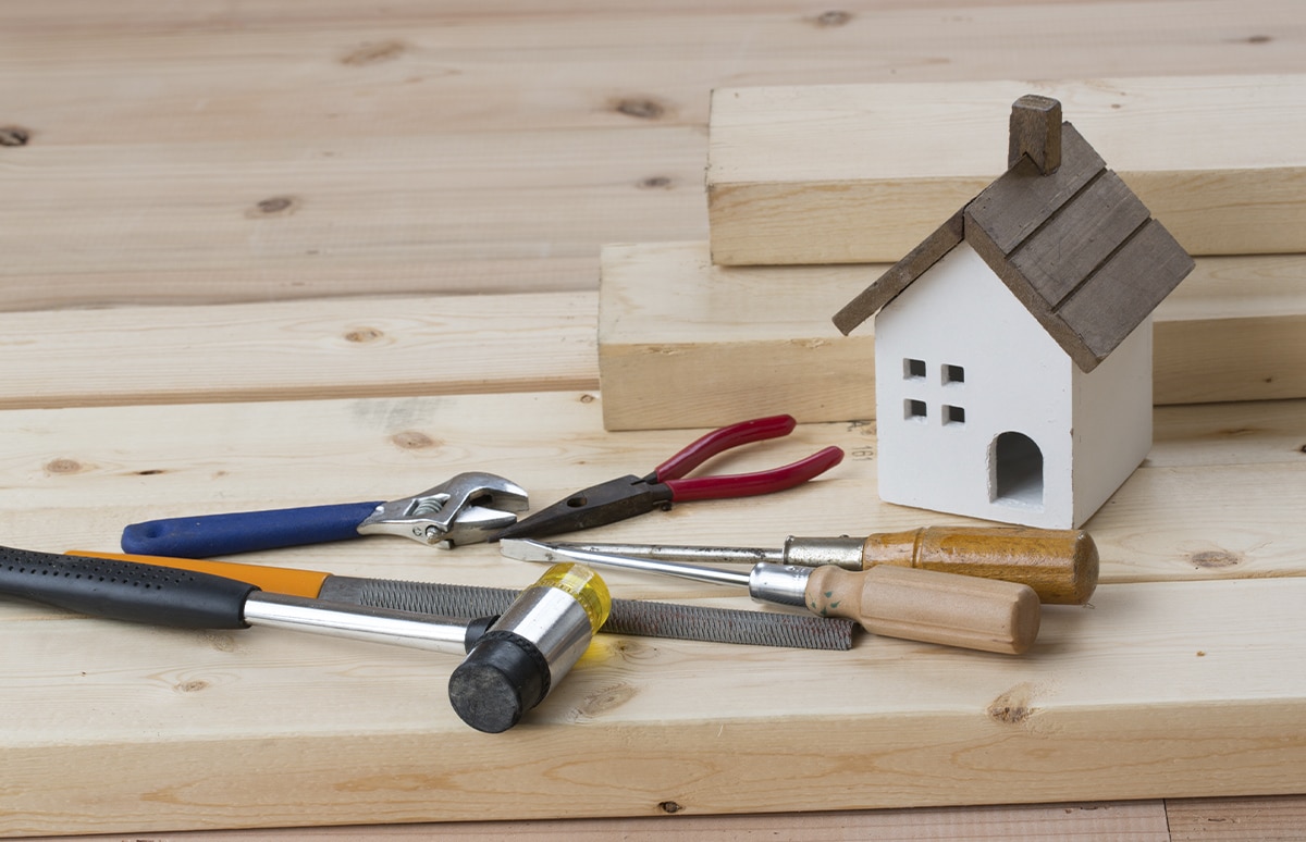 Casa de madera junto con herramientas para realizar una reforma