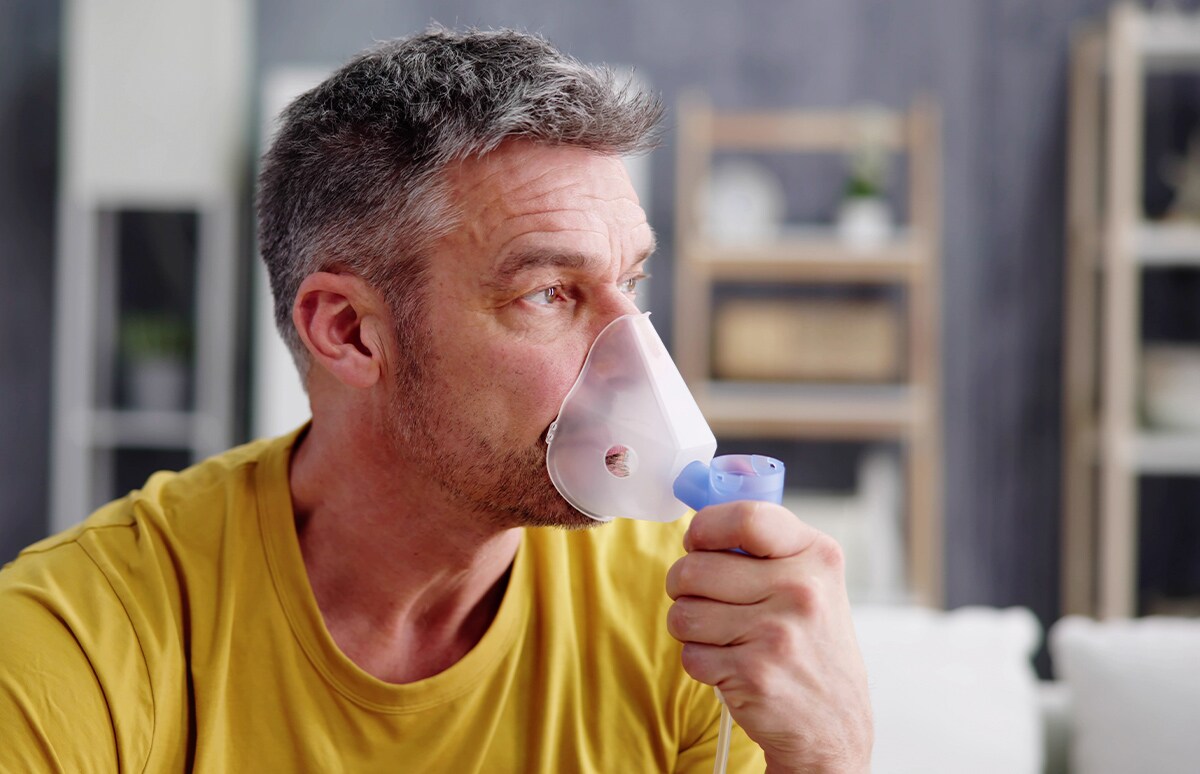 Hombre sereno, respirando con un inhalador