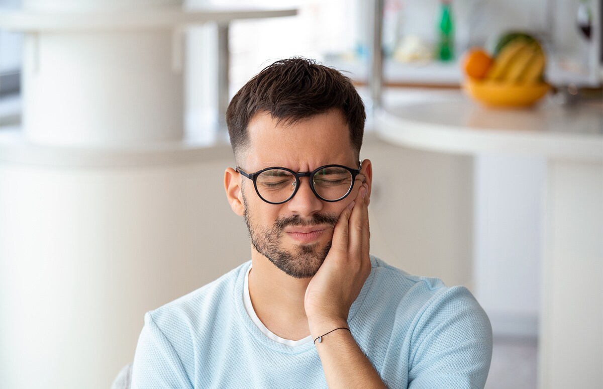 Hombre quejándose de dolor en la boca