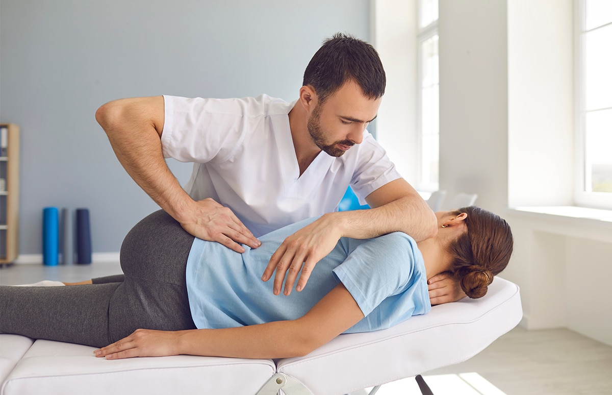 Osteópata manipulando la espalda a una paciente