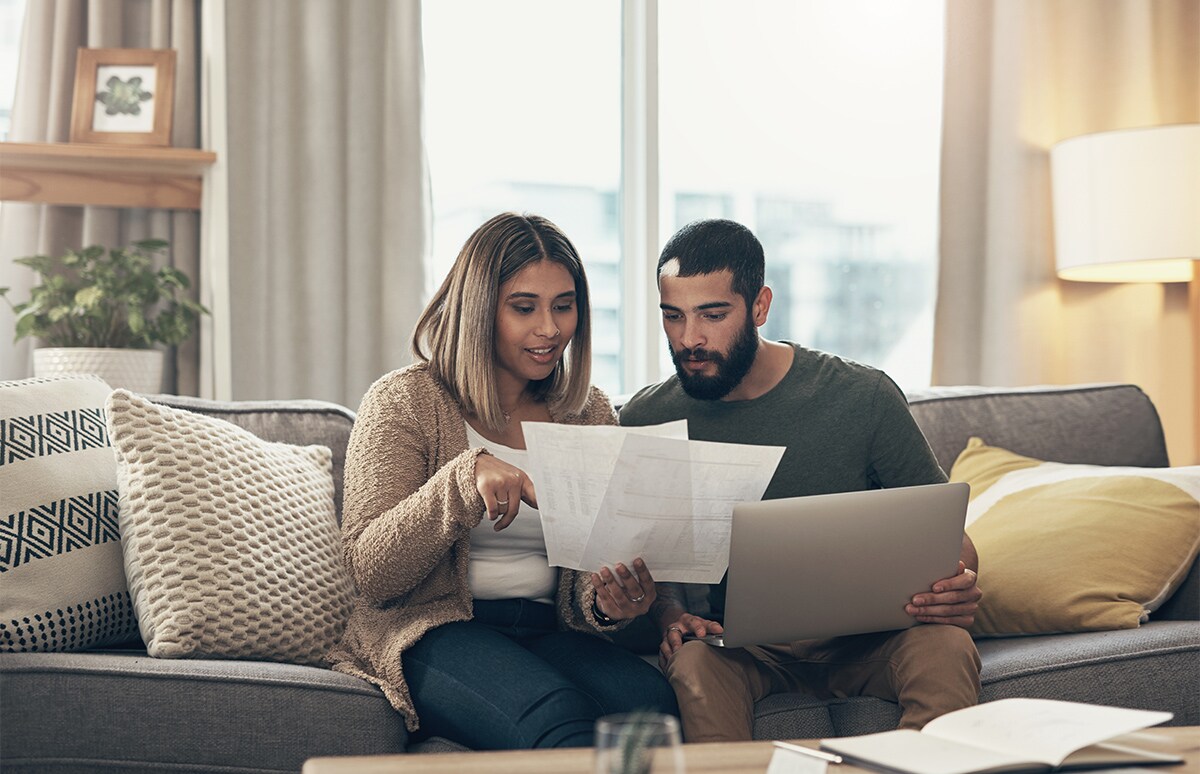 Pareja en un salón comprobando papeles de su seguro de vida