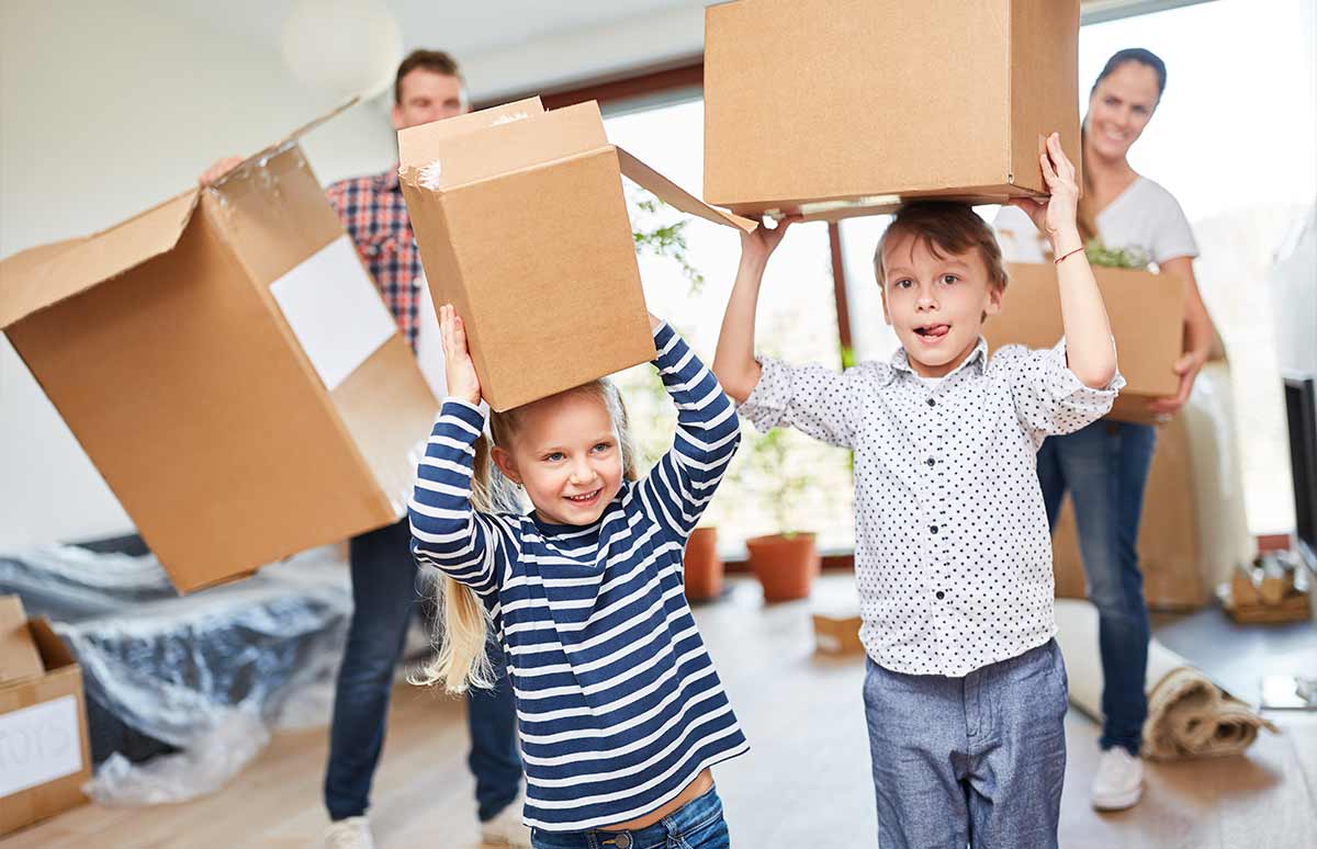 Preparativos de una mudanza familiar con el traslado de cajas de cartón al nuevo domicilio