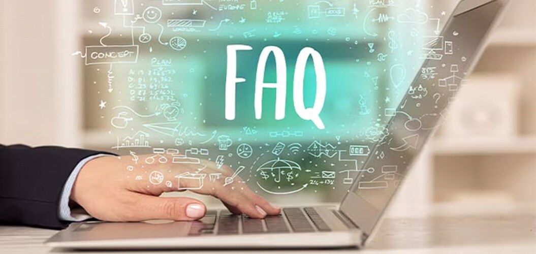 Mano utilizando un ordenador portátil con la palabra “FAQ” resaltada sobre iconos y gráficos digitales