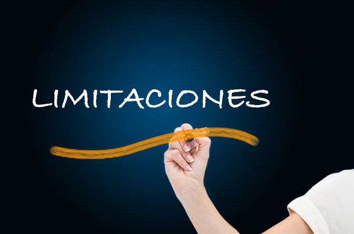 Mano escribiendo la palabra “LIMITACIONES” en una pizarra oscura con un trazo curvo en color naranja